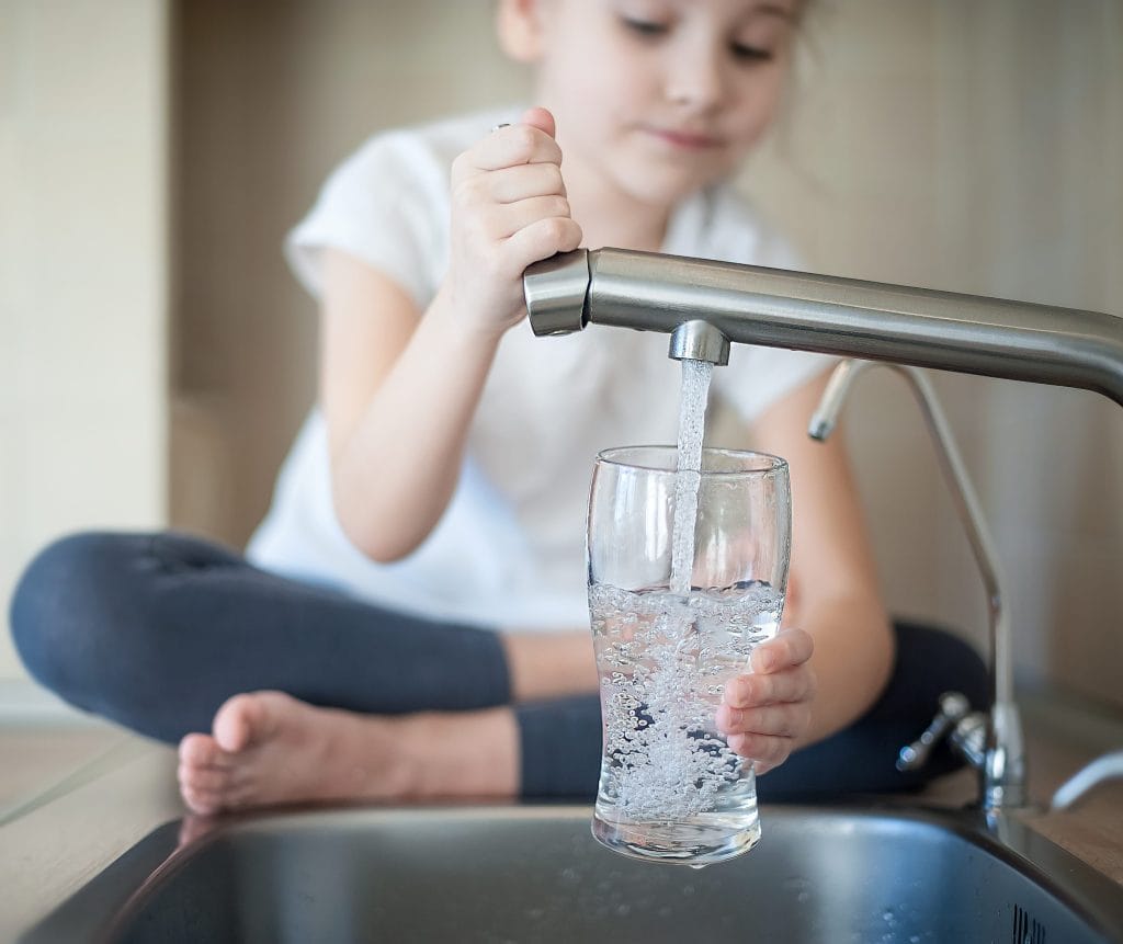 Stock image of a girl pouring a glass of water.