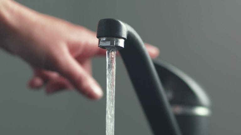 Stock image of water coming out of a faucet.