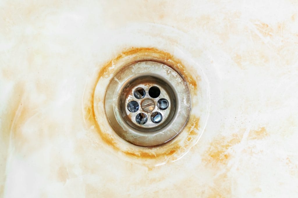 Stock image of an orange-stained sink due to iron in water.