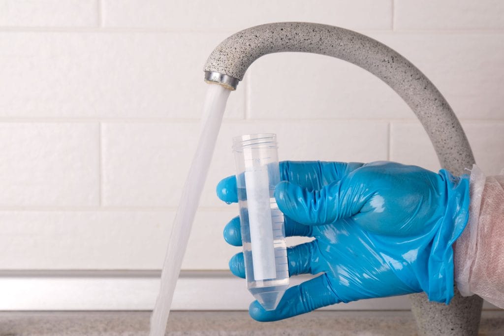 Stock photo of tap water being collected for testing.